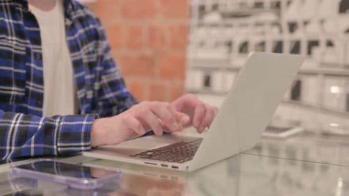 Seitenansicht eines Mannes, der am Laptop arbeitet
