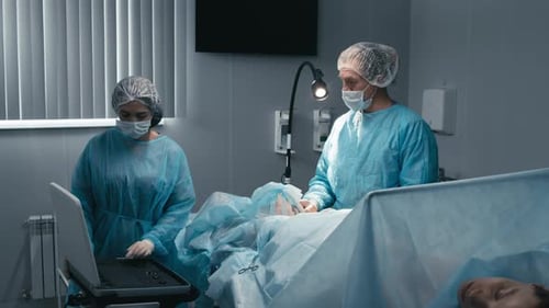 Surgeons Operating on Patient in Hospital Operating Room