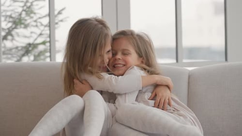 Two Adorable Young Girls Laughing and Embracing