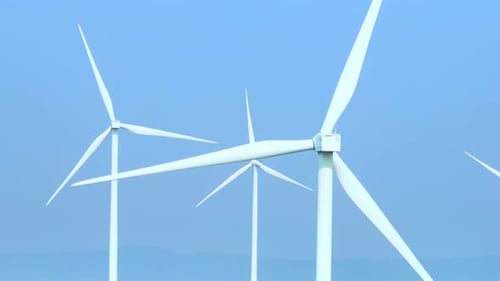 A vast array of towering wind turbines from aerial view drone.
