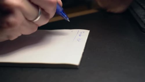 Hand Writes To-Do List on Notepad at Desk