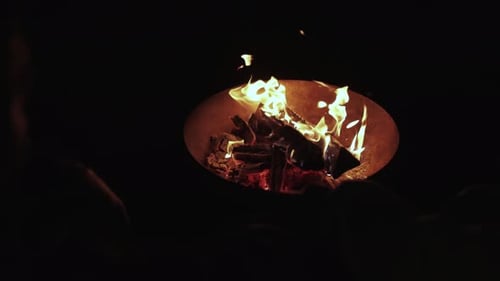 Closeup Iron Fire Pit and Burning Fire in a Garden Fireplace in the Backyard of Family House Burning
