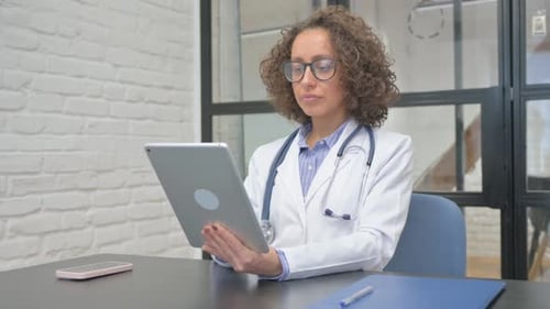 Female Doctor Working with Tablet in Clinic