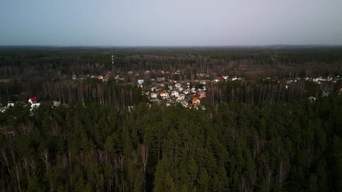 Aerial View of a Small Town Surrounded By Lush Forest Under a Clear Sky