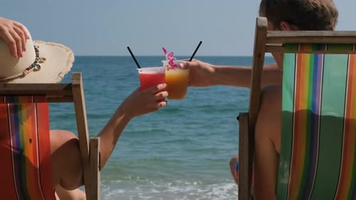 Man with Woman Clinking Cocktails in Beach Chairs
