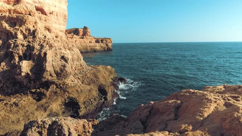 Aerial shot of beautiful rocky beach surrounded by cliffs in Algarve, Portugal.