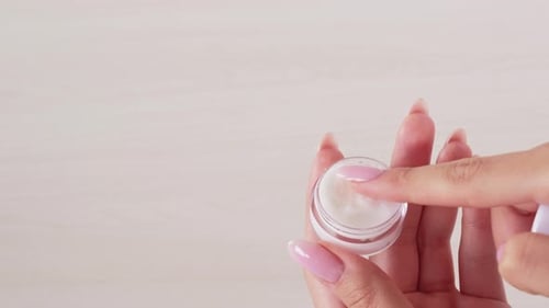 Hand Opens Jar of Cream for Beauty Treatment