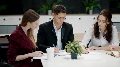 Group of Four Colleagues Gathered Around a Table in an Office Setting Engaged in a Collaborative
