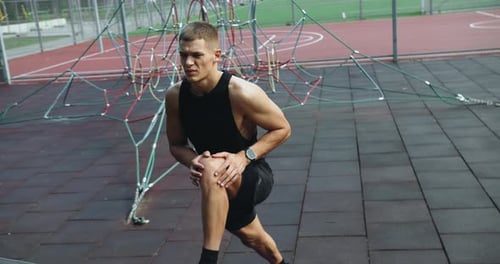 Athletic Man Training at Sports Court Outdoors and Doing Side Lunges Exercise