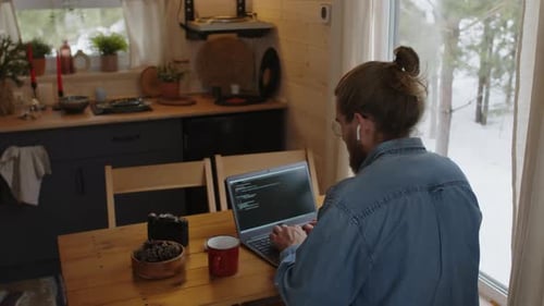 Male Software Developer Working on Laptop at Home