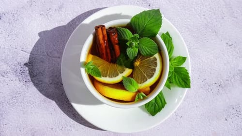 Zoom in Out Black and Green Tea with Lemon Cinnamon Sticks and Mint Leaves