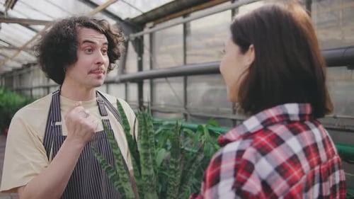 A Male Sales Consultant Gives Advice to the Buyer on Caring for Plants A Male Plant Botanist