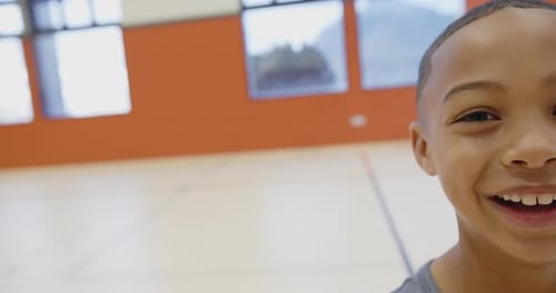 Smiling boy in school gymnasium enjoying physical education class activities