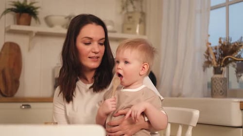 Mother and Child with Spoon in Bright Kitchen