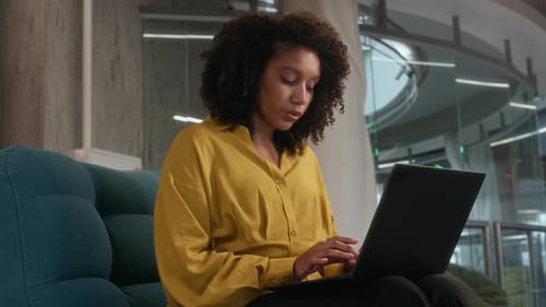 Femme indépendante travaillant sur un ordinateur portable dans un espace de bureau