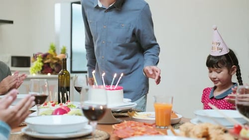 Family Celebrates Birthday with Cake and Candles