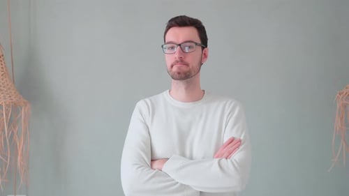 Man with Glasses Stands with Arms Crossed