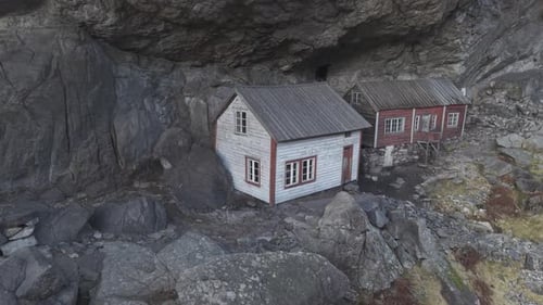 Helleren historical site in Norway. Two old house under cliff. Rotating drone footage