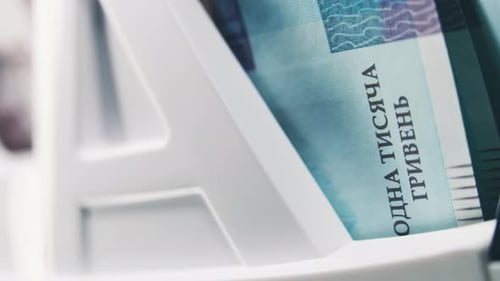 Close Up of Bill Counter Counting Thousand of Hryvna Bank Notes