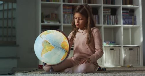 Girl Exploring the World Globe in Her Room