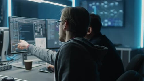 Two Men Coding and Discussing in a Tech Office