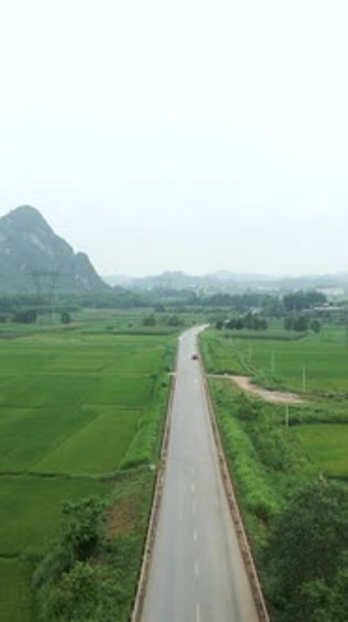 a Long Straight Road Crosses the Green Valley Surrounded By Crop Fields in Vietnam