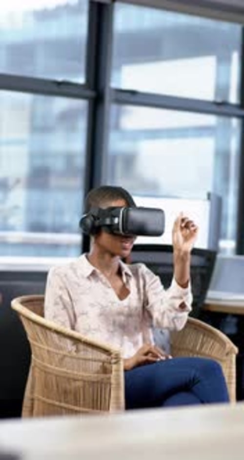 Vertical video of african american businesswoman using vr headset in office, slow motion, copy space