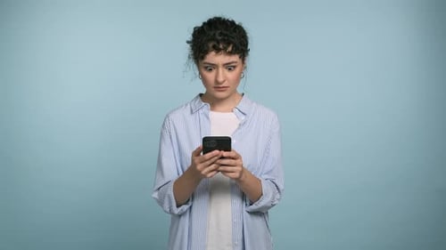 Surprised Woman Using Smartphone on Blue Background