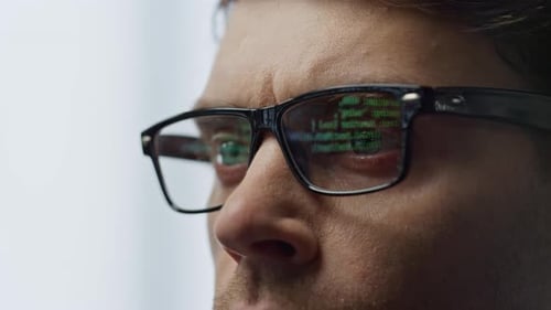 Software developer in glasses reflecting terminal code overlook cyber security