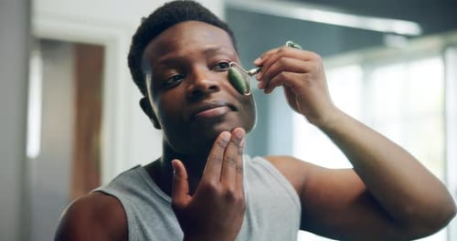 Man Using Facial Jade Roller For Skin Care