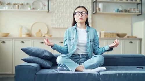 Woman Meditating on Sofa in Home Interior