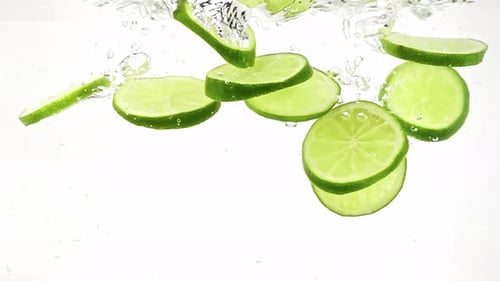 Lime Slices Falling into Clear Refreshing Water