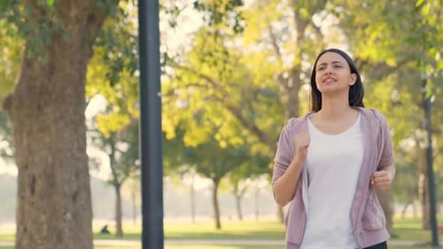 Young Woman Jogging in a Sunny Urban Park