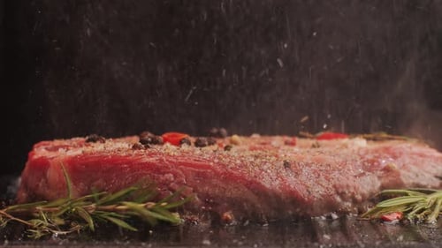 Fresh Marbled Beef with Pepper Salt and Rosemary Closeup Macro Cooking Juicy Steak on Grill with Oil