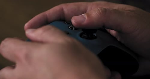 Hands playing video games with a controller in close up