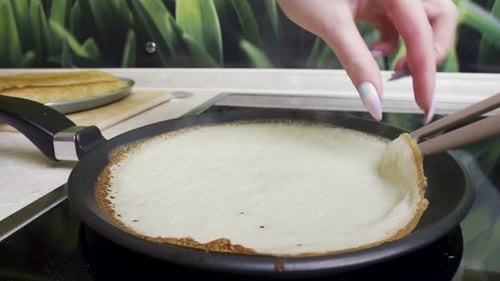 Fry the pancake in a pan, turn the pancakes, close-up.