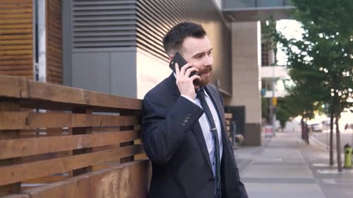 Businessman in Suit Talking on Smart Phone on City Sidewalk Adult