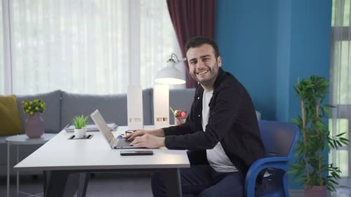 Man Working on Laptop at Home Desk