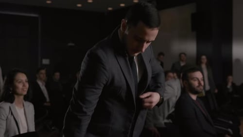 Crowded business conference hall with people listening to man speech in slow motion