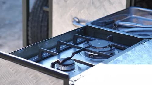 Empty stove in camper van outdoor look .Portable cooking gas stove flame lighting on road trip, slow