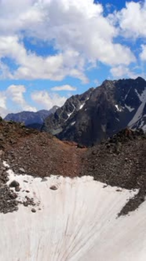 Scène alpine avec des pentes glacées, un bol de montagne majestueux avec des pentes d'éboulis abruptes sous un bleu clair
