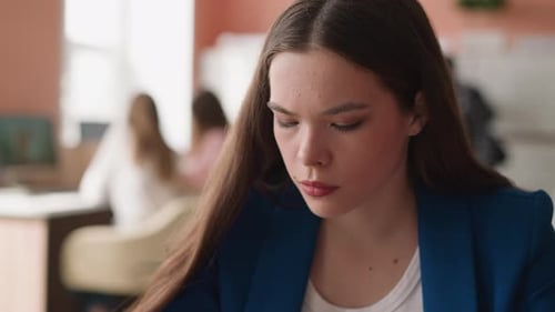 Focused Woman Looks Downward in Library Premise