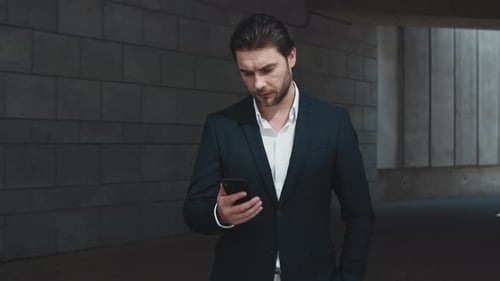Confident businessman typing message on smartphone in the city outdoors