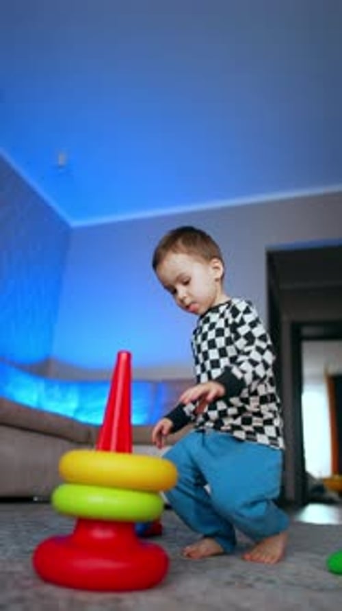 Child Playing with Stacking Ring Toy at Home