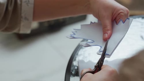 Hands Cutting Paper with Scissors for Crafting