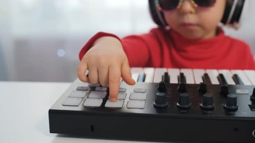 Little Girl Plays Electronic Keyboard with Headphones