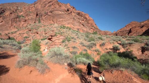 St George Hiking Trail, Utah USA, Slow Motion of Young Female Hiker Under Red Sandstone Hills on Hot