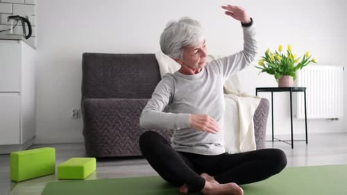 Mature Woman Doing Yoga at Home on Exercise Mat