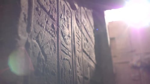 Close details of hieroglyphs litten by sunlight on the walls inside the temple of Philae, Aswan, Egy