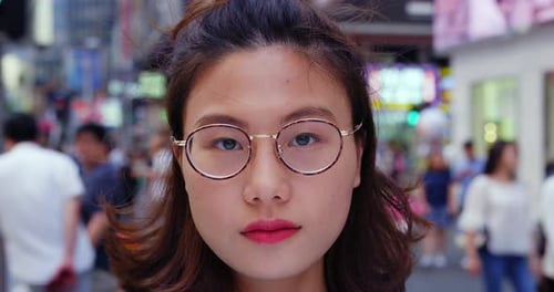 Portrait Of Young Trendy Asian Woman At Camera In The Street Of Causeway Bay Honk Kong. Slow Moti...